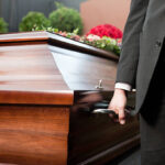 Dolor - Funeral with coffin on a cemetery, the casket carried by coffin bearer