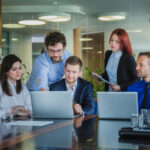 A group of professionals collaborating in a Canadian office environment, representing skilled workers eligible for the Canadian Experience Class.