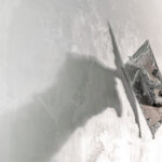 Close-up of a worker using a metal trowel to apply a smooth layer of moisture-resistant plaster to an interior wall, showcasing advanced damp proofing techniques for high-humidity environments.