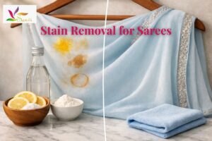Georgette saree with turmeric, oil, and tea stains beside lemon, vinegar, and cornstarch remedies on marble surface, showing before-and-after stain removal.