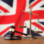 United Kingdom flag and golden scale with a judge's gavel