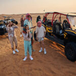 Beautiful people in Dubai desert with quad bikes. Vacation mood.