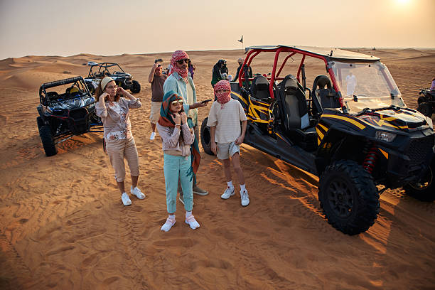 Beautiful people in Dubai desert with quad bikes. Vacation mood.