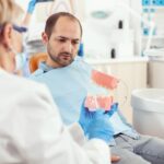 stomatologist-explaining-proper-dental-hygiene-using-teeth-skeleton-stomatology-appointment_482257-4910