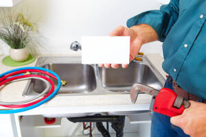 Plumber with Plumbing tools on the kitchen. Renovation.